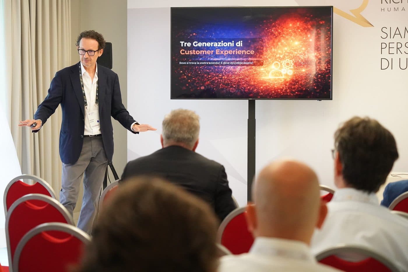 Gianluca Carrera presenting three generations of customer experience to a seated audience